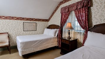 Une chambre avec deux lits, une table de chevet en bois, une chaise et une fenêtre avec des rideaux.