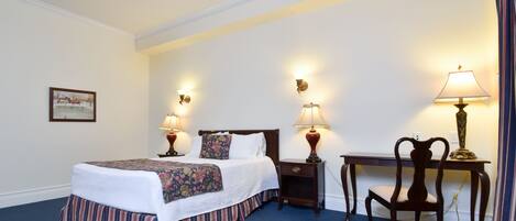 A neatly arranged hotel room with a bed, bedside tables with lamps, a desk, and a chair.