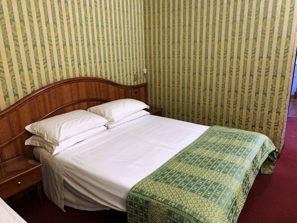 A neatly made bed with white linens in a room with striped wallpaper. - Re Luxury Accomodations (Rome)