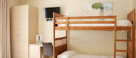 Habitación con literas, un escritorio, un televisor y un cuadro en la pared.