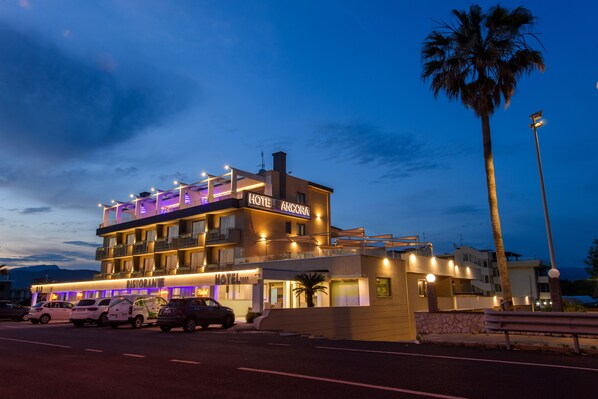 A multi-story hotel with a restaurant on the ground floor, a pool, and a view of the ocean. - Hotel Ancora (Pontecagnano Faiano)