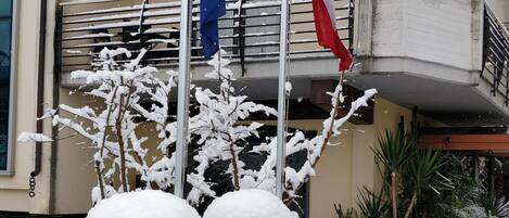 A building with balconies and a snow-covered entrance.