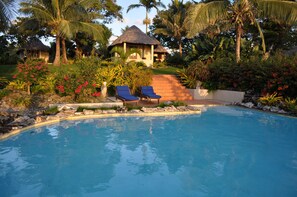 Una piscina al aire libre, sillones reclinables de piscina