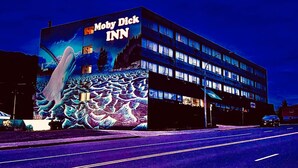 Un edifici amb un mural gran que fa publicitat a 'Moby Dick Inn'.