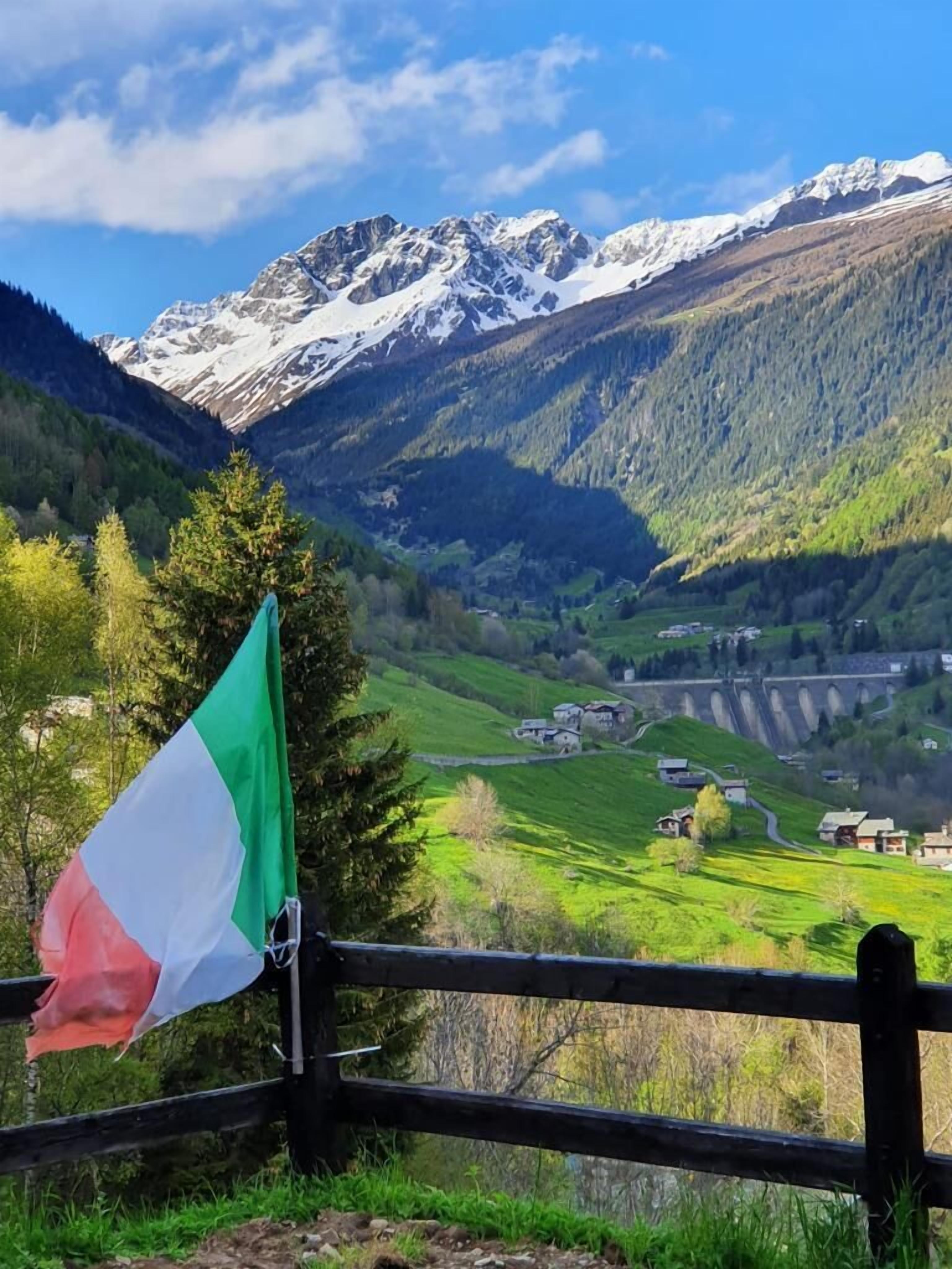 Un paisaje montañoso con una bandera en una valla.