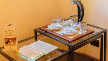 Una mesa de vidrio con una cafetera, tazas y un menú.