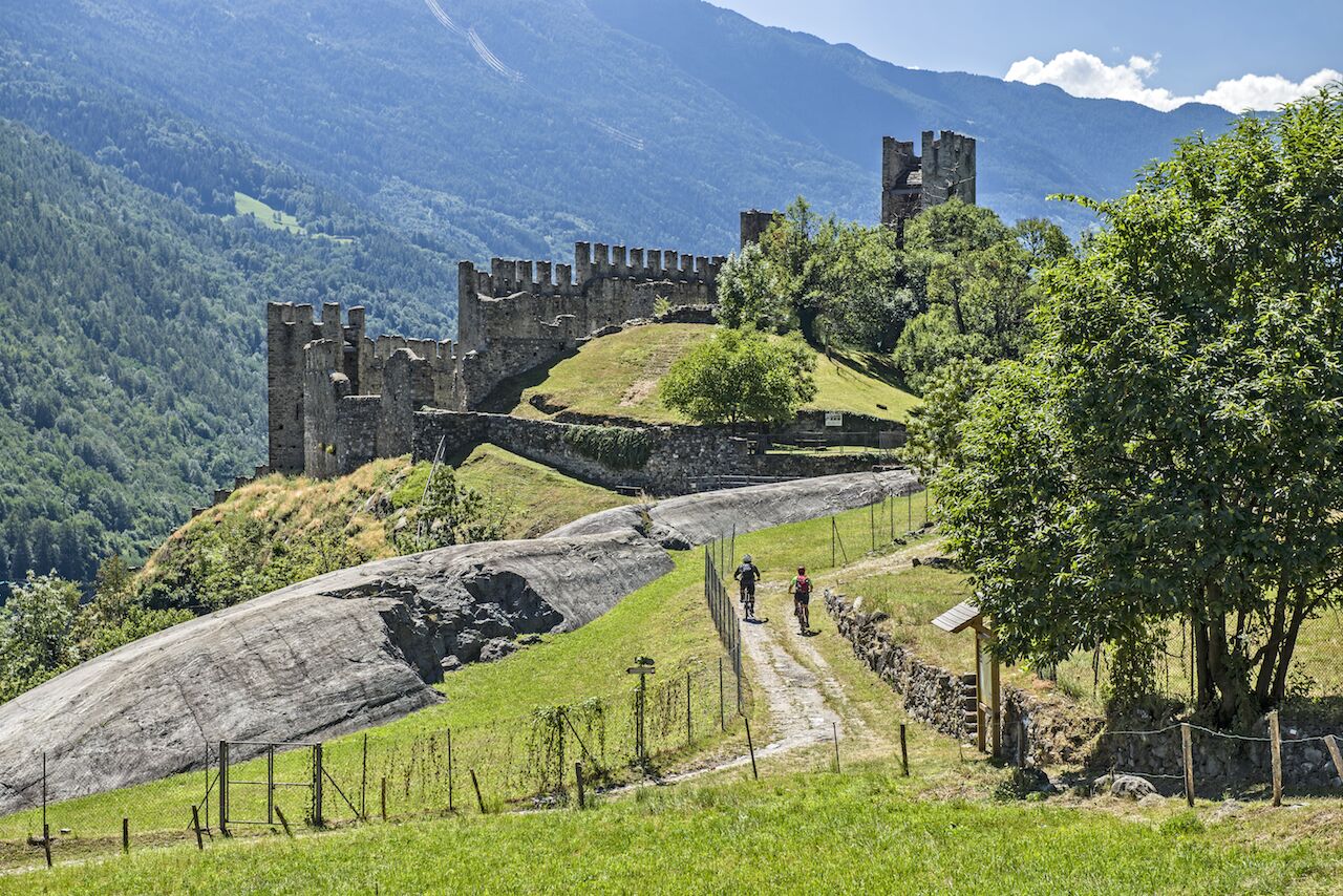 A castle on a hill with a dirt path leading to it.