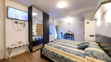 Een moderne hotelkamer met een groot bed, een bureau en een aan de muur bevestigde televisie.