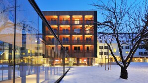 A modern building with multiple balconies and large windows, surrounded by snow. - Hotel Balnea Superior – Terme Krka (Dolenjske Toplice)