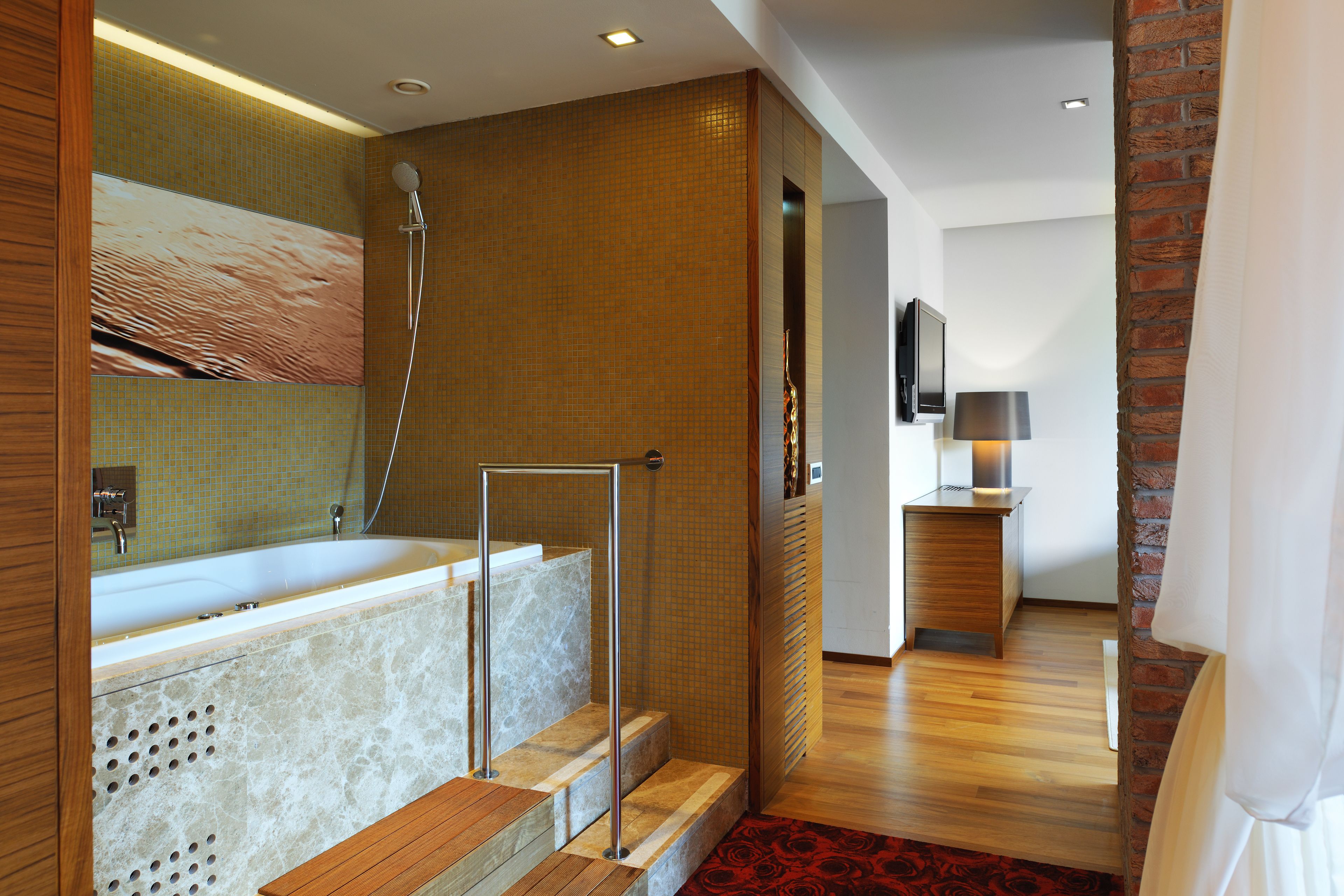 A modern bathroom with a freestanding bathtub, a shower, and a wooden floor.