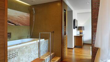 A modern bathroom with a freestanding bathtub, a shower, and a wooden floor.