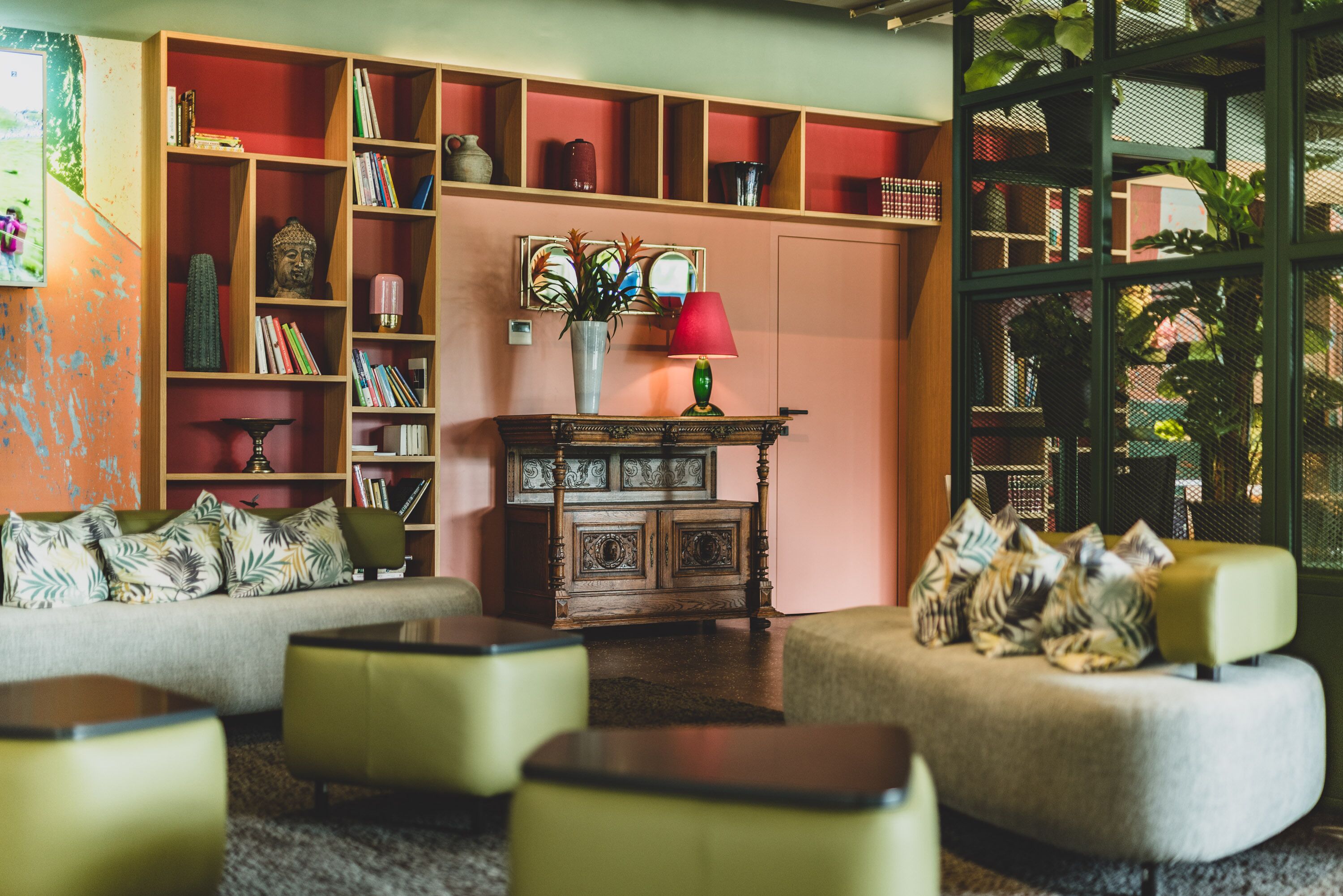 A cozy living room with a bookshelf, a wooden cabinet, and a green sofa.