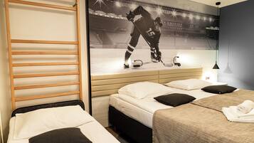 A hotel room with two beds, a wooden ladder, a hockey player on the wall, and a nightstand with a lamp.
