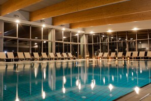 A swimming pool with lounge chairs and large windows. - Sport - Terme Krka (Novo Mesto)