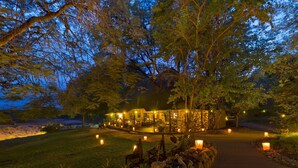 A well-lit outdoor area with a dining setup and a building in the background. - Motswari Private Game Reserve Resort by NEWMARK (Bushbuckridge)