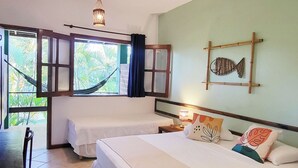 Quarto com duas camas, uma rede, luminária pendente e arte de parede com tema de peixes.