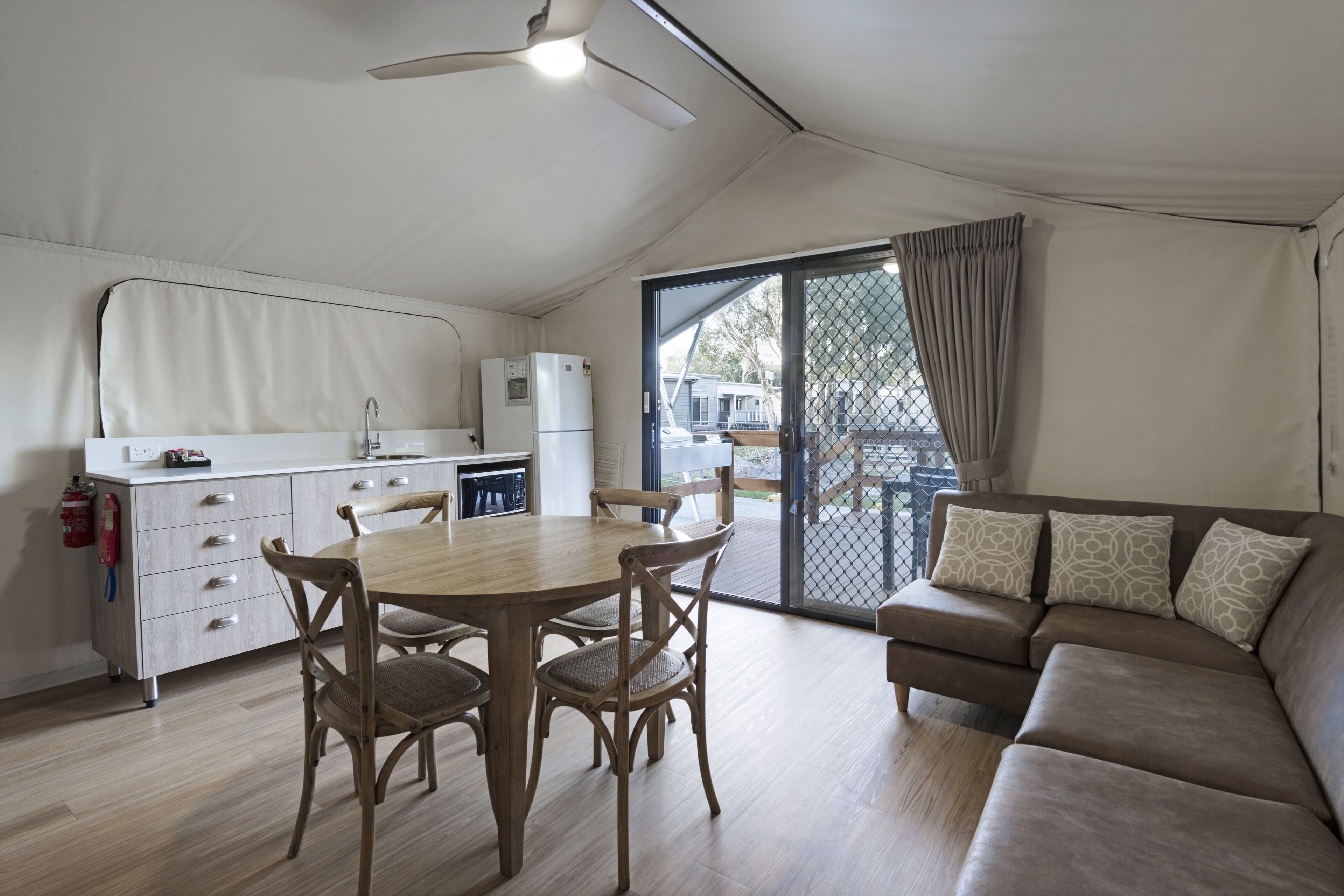 A compact living space with a kitchenette, dining area, and a sofa.