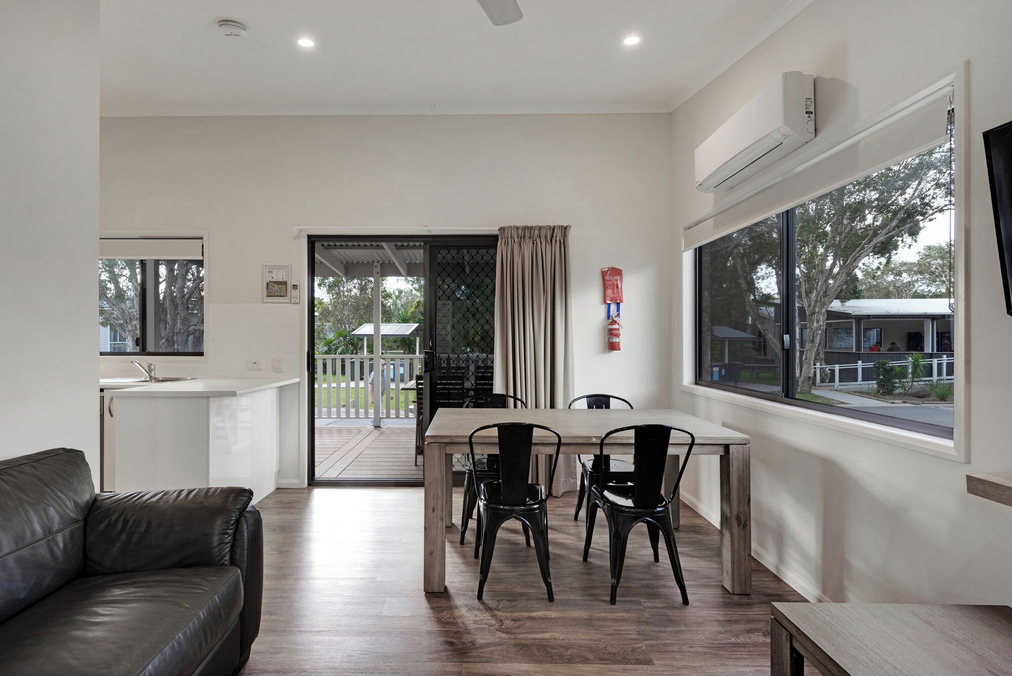 A modern kitchen with a built-in oven and a dining area with a table and chairs.