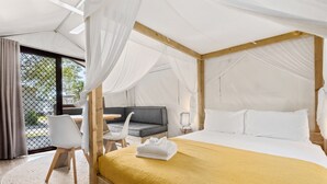 Un dormitorio con cama a dosel, sofá y zona de comedor.