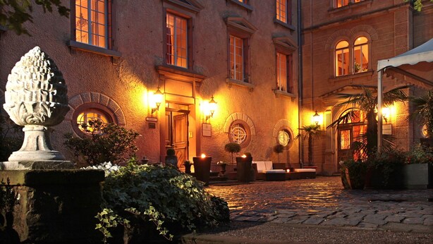 Un edificio histórico con patio, columnas de piedra y una fuente.