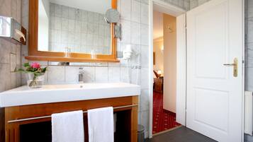 A bathroom with a white sink, a mirror, and a towel rack.