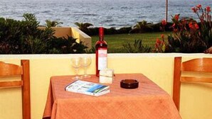 A table set for two with a bottle of wine, glasses, and a menu on a tablecloth. - Nautilus Apartments (Agios Nikolaos)