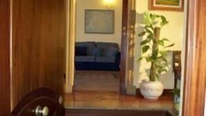 A wooden staircase leading to a living area with a sofa and a potted plant. - Marchese Sala (Agrigento)