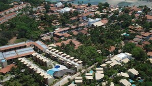 An aerial view of a coastal resort with multiple bungalow-style buildings, a central swimming pool, and a beach in the background. - CostaSol Pipa (Tibau do Sul)