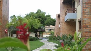 A brick building with a pathway leading to a covered area. - CostaSol Pipa (Tibau do Sul)
