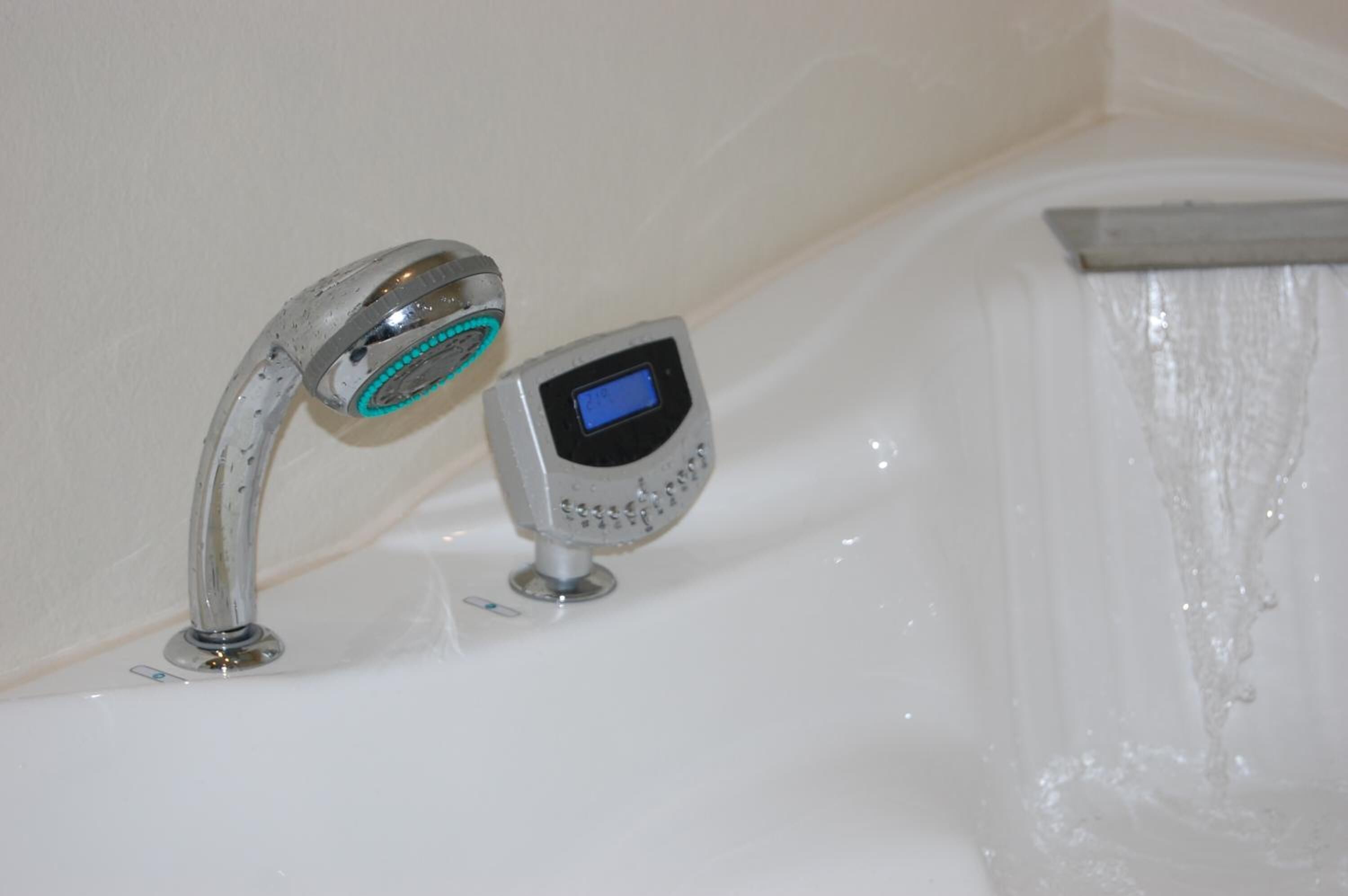 Ein Badezimmer mit Bedienfeld für Dusche und Handbrause.