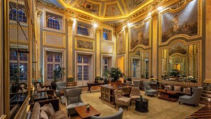 Un lobby de hotel lujoso con decoración elaborada, grandes ventanales y cómodas zonas de estar.