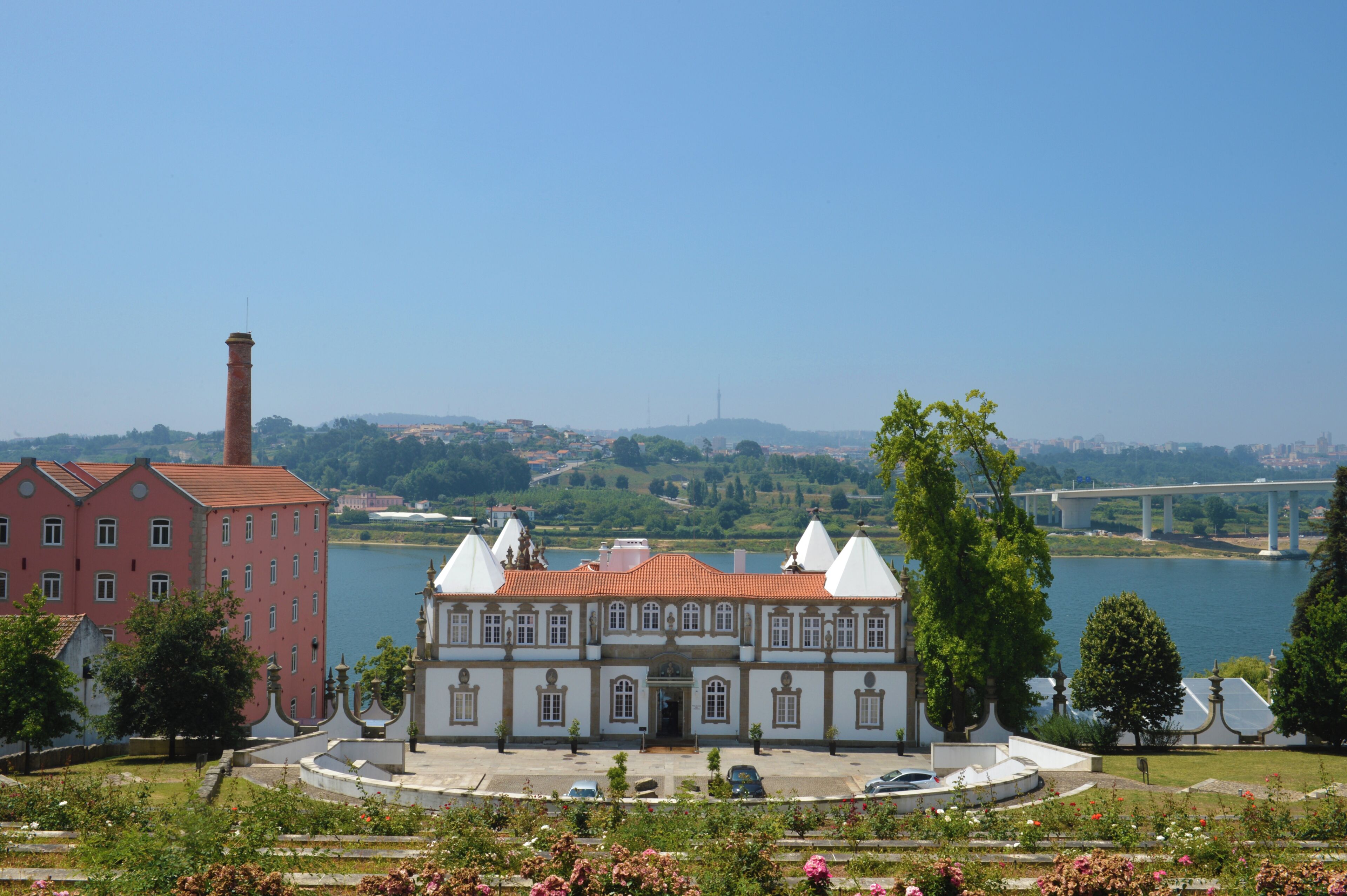 A historic building with a central courtyard, a river in the background, and a bridge.