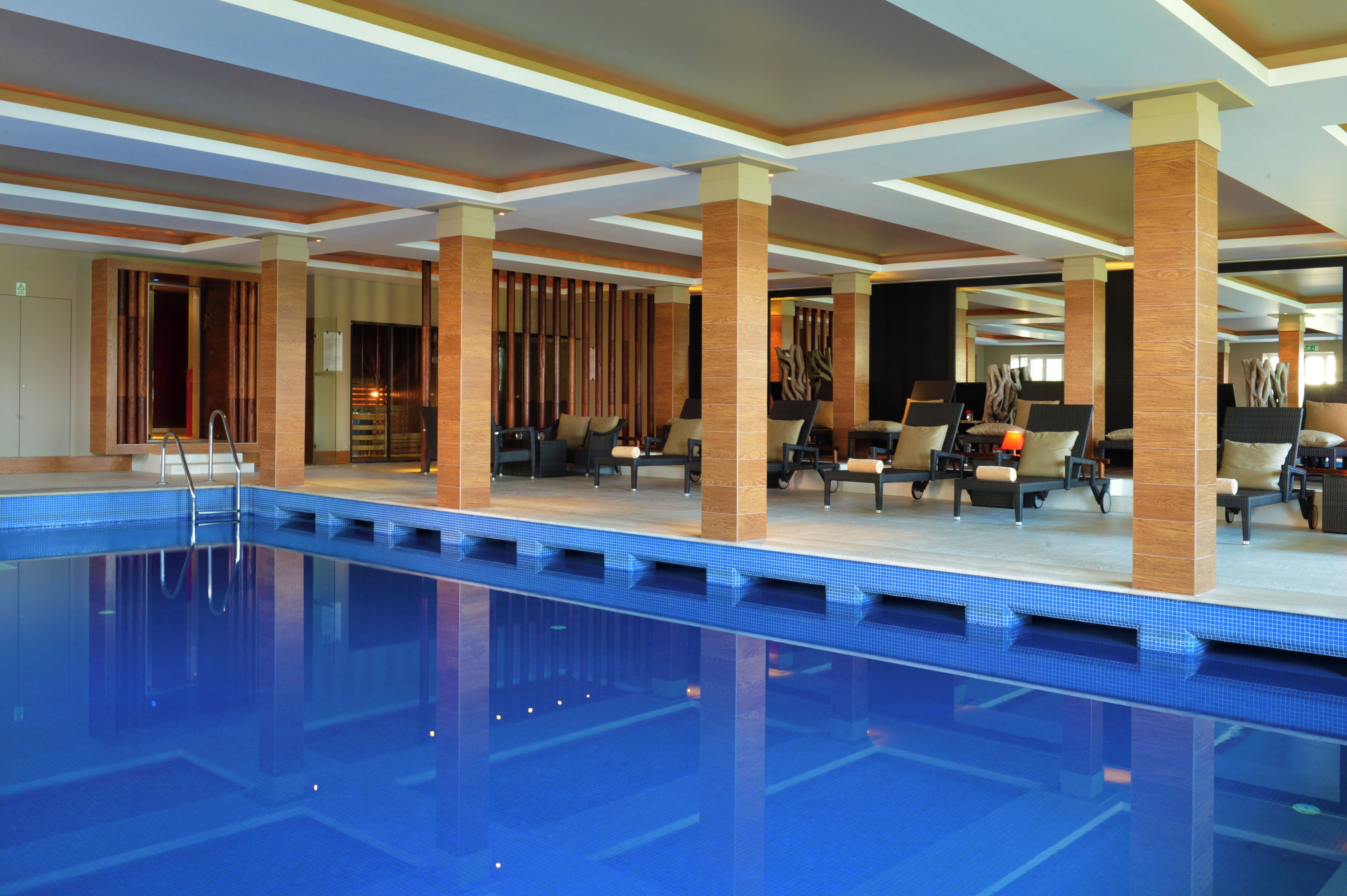 A swimming pool with lounge chairs and a modern interior design.