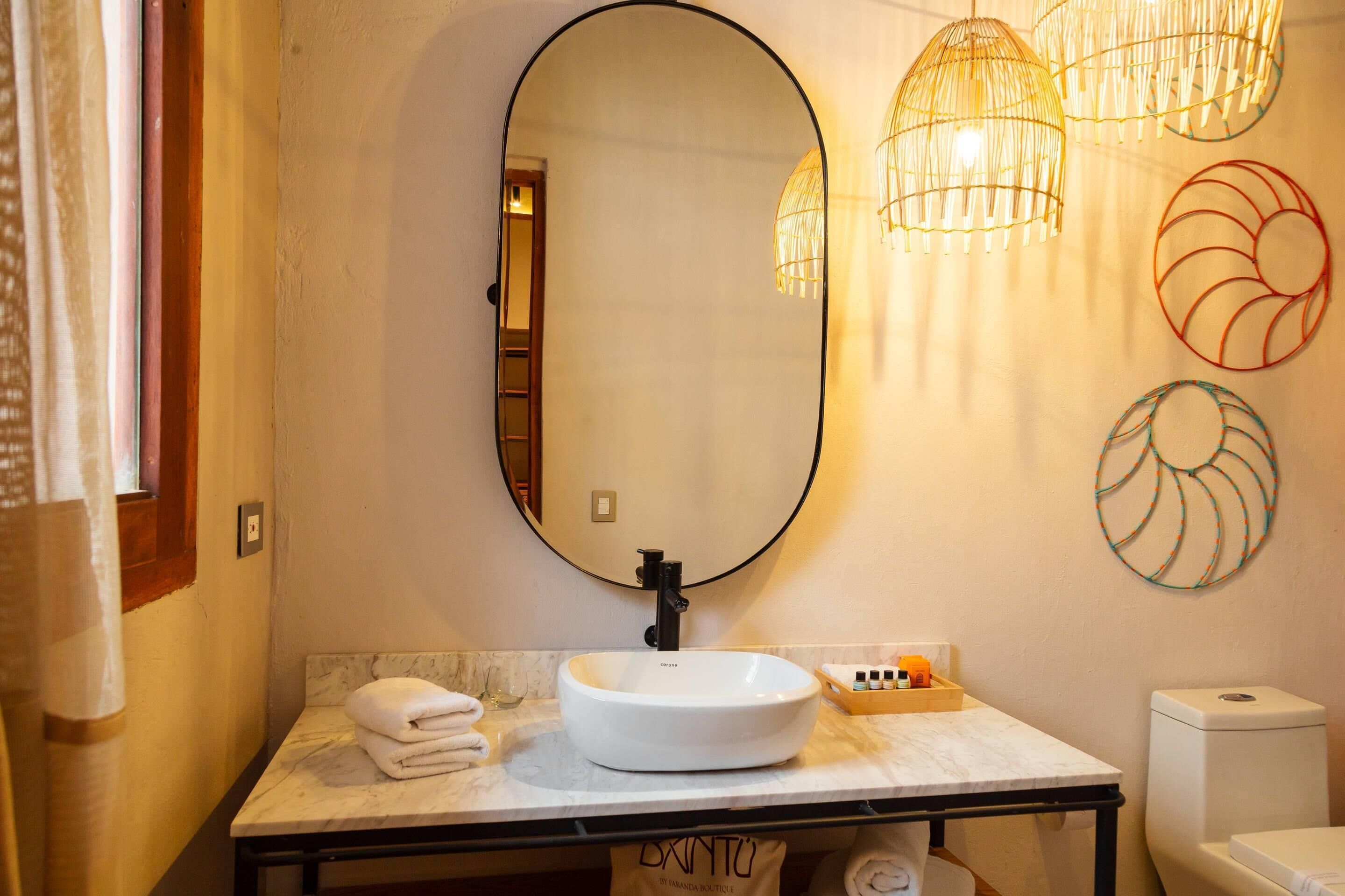 A bathroom with a white sink, a large mirror, and a toilet.