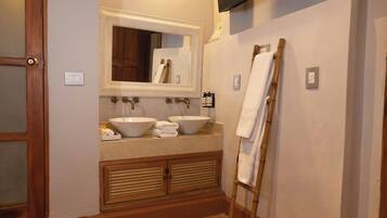 A bathroom with a double sink, a large mirror, and a wooden vanity.
