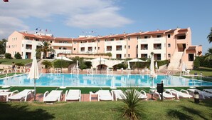 A hotel with a swimming pool, multiple balconies, and a well-maintained lawn. - Heraclea Hotel Residence (Policoro)