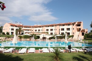 Una piscina al aire libre de temporada, sombrillas