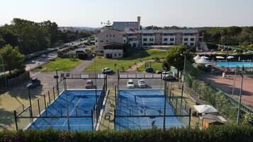Um hotel com piscina, estacionamento e um edifício grande com vários andares.