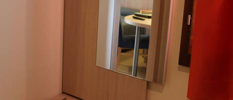 A bathroom with a wooden vanity, a mirror, and a towel rack.