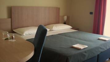 Una habitación de hotel con una cama, una mesa redonda y una silla.