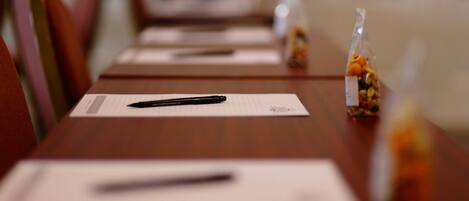 A conference table with a pen, notepaper, and a bag of snacks.