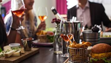 A dining table with food, drinks, and a burger.