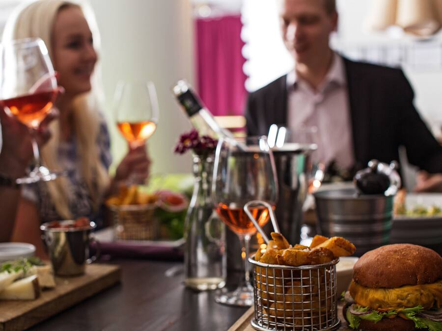 A dining table with food, drinks, and a burger.