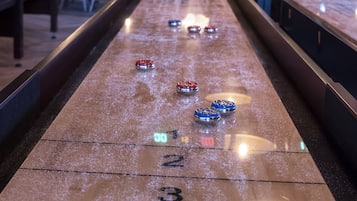 Taula de palissada amb zones de puntuació numerades i discos en moviment.