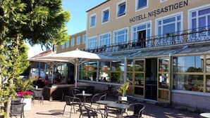 Un hotel con asientos al aire libre y un patio techado.