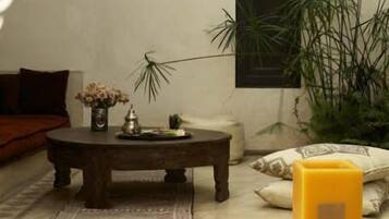 Habitación con piscina, una mesa redonda de madera, una planta en maceta y una ventana.