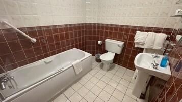 A bathroom with a bathtub, toilet, and sink.