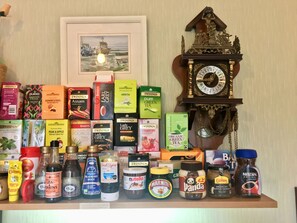 Un estante con diferentes cajas de té, botellas y tarros.