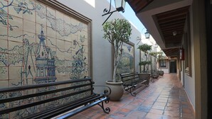 Un camino empedrado con bancos y una pared decorativa.