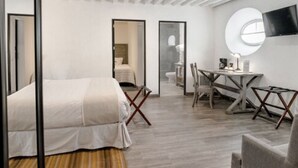 Una habitación de hotel moderna con una cama, un escritorio y un televisor.